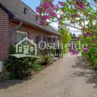 Blick aus dem Carport auf die gepflasterte Einfahrt und den einladenden Haupteingang des Klinker-Einfamilienhauses in Karwitz-Lenzen.
