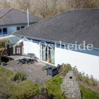 Luftaufnahme des Garten des Bungalow in Sassnitz mit Fokus auf die nach Süden ausgerichtete Terrasse.