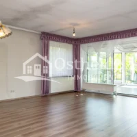 Lichtdurchflutetes Wohnzimmer der Immobilie in Karwitz mit direktem Blick auf den angrenzenden Wintergarten.