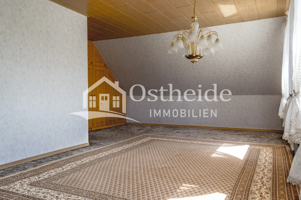 Großes, helles Zimmer im Obergeschoss der Immobilie in Karwitz mit ca. 30m² Wohnfläche, zwei großen Fenstern und einem maßangefertigten Einbauschrank.
